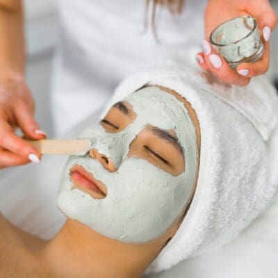 professional putting facial mask for her client